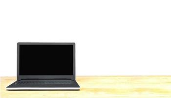 Laptop auf Tischplatte gegenüber dem weißen Hintergrund isoliert. Foto enthält Beschneidungspfad des leeren Bildschirms.