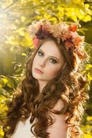 junge frau, die ein paar gelbe ahornblätter hält. Herbstportrait der jungen Frau. rothaariges Mädchen im Herbstwald foto