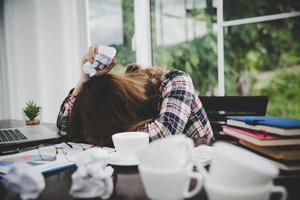 junge frustrierte frau, die im büro arbeitet foto