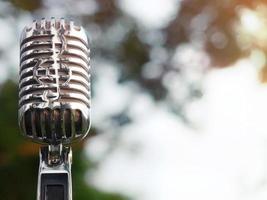 Retro-Mikrofon zum Aufnehmen und Aufführen für Sänger auf der Bühne. Bokeh heller Hintergrund kann Werbetext setzen. foto