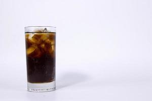 Ein isoliertes Glas schwarzer Cola mit Eis wird auf weißem Hintergrund gefüllt, der in Anzeigen verwendet wird foto
