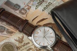 Uhr und Geldbörse auf Banknote foto