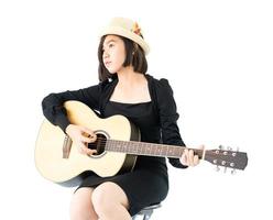 Frau sitzt und spielt Gitarre Gitarren-Volkslied in ihrer Hand foto