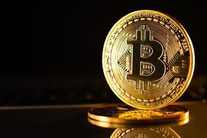 goldene Münzen mit Bitcoin-Symbol auf schwarzem Hintergrund. foto