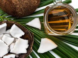 Kokosfleisch und Kokosöl in Glasflasche auf Kokosblatt. foto
