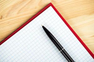 leeres Notizbuch mit Stift und Bleistift auf Holztisch foto