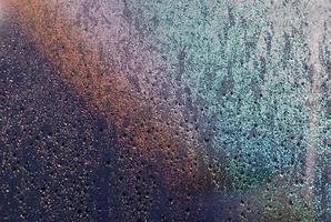 Fokus und verschwommenes Foto von Regentropfen auf Glasfenster mit dunkelblauer Farbe und Lichtreflexion darauf für abstraktes und Hintergrundkonzept.