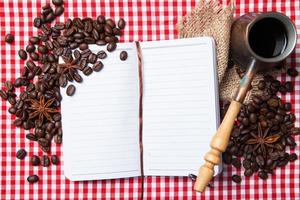 leeres Papier, Kaffeebohne und Kaffeetasse auf Holz