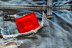 kondom in der jeanstasche für safer sex, weltweite sexuelle gesundheit und aids-tageskonzept. foto