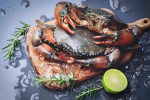 rohe Krabbe auf Holzschneidebretthintergrund, frische Schlammkrabbe mit Eis zum Kochen von Speisen im Fischrestaurant foto