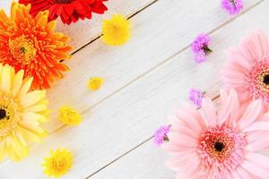 frische frühlingsblumen gerbera bunt und verschiedene blumen auf hölzernem weißem hintergrund foto