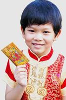 junge zeigt glücklich seinen geldgeschenkumschlag beim chinesischen neujahrsfest. Foto ist auf seine Augen gerichtet.
