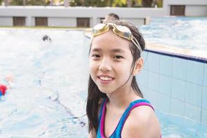 asiatisches glückliches kind im schwimmbad foto