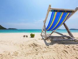 entspannen sie sich im strandkorb mit frischer kokosnuss auf einem sauberen sandstrand mit blauem meer und klarem himmel - meeresnaturhintergrund relaxkonzept foto