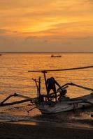 primitives asiatisches Fischerboot bei Sonnenuntergang foto
