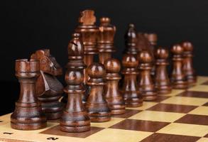 Schachbrett mit Schachfiguren auf schwarz isoliert foto