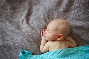 Neugeborenes Baby des Schlafenden auf einem grauen Hintergrund