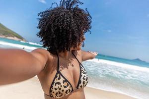 schwarzes afro junges süßes mädchen, lockiges haar, bikini, strand. afroamerikanischer Sommerurlaub. foto