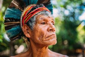 Indianer vom Pataxo-Stamm, mit Federschmuck. älterer brasilianischer Indianer, der nach rechts schaut. Fokus auf Gesicht