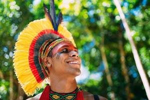 Indianer vom Pataxo-Stamm mit Federschmuck nach rechts schauend. einheimisch aus brasilien mit traditioneller gesichtsbemalung. Konzentrieren Sie sich auf das Gesicht