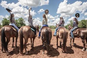fünf junge Frauen, die auf ihren wunderschönen Pferden reiten foto