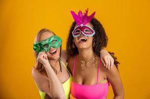 schöne frauen, die für die karnevalsnacht gekleidet sind. lächelnde frauen bereit, den karneval mit einer bunten maske zu genießen. foto