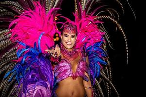 Brasilianer mit Samba-Kostüm. schöne brasilianische frau, die bunte kostüme trägt und während der carnaval street parade in brasilien lächelt. foto
