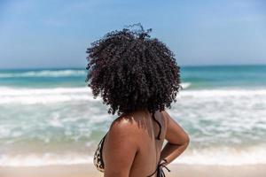 schwarzes afro junges süßes mädchen, lockiges haar, bikini, strand. afroamerikanischer Sommerurlaub. foto