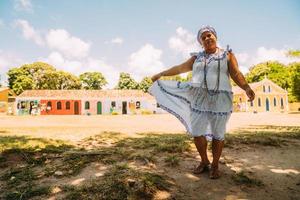 Fröhliche Brasilianerin in traditioneller bahianischer Tracht der Umbanda-Religion im historischen Zentrum von Porto Seguro foto