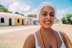 Fröhliche Brasilianerin in traditioneller bahianischer Tracht, die im historischen Zentrum von Porto Seguro tanzt. Fokus auf Gesicht foto