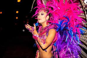 Brasilianer mit Samba-Kostüm. schöne brasilianische frau, die bunte kostüme trägt und während der carnaval street parade in brasilien lächelt. foto