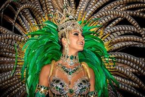 Brasilianer mit Samba-Kostüm. schöne brasilianische frau, die bunte kostüme trägt und während der carnaval street parade in brasilien lächelt. foto