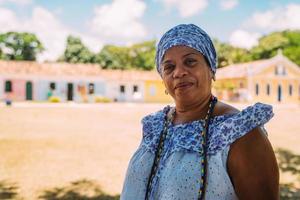 Fröhliche Brasilianerin in traditioneller bahianischer Tracht der Umbanda-Religion im historischen Zentrum von Porto Seguro foto