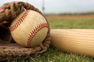 Baseball in einem Handschuh mit Schläger foto