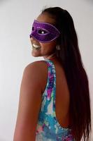 glückliche junge frau mit maske und konfetti auf karnevalsparty. brasilianischer Karneval foto