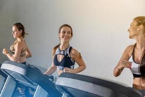 attraktive junge sportlerinnen trainieren im fitnessstudio. Cardio-Training auf dem Laufband machen. Laufen auf dem Laufband. foto