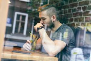 junger Mann trinkt Limonade in einem Café. foto