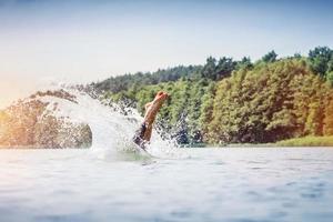 junger Mann, der in einen See taucht. foto