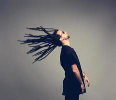 junger Mann, der seine Dreadlocks zurückschlägt. foto