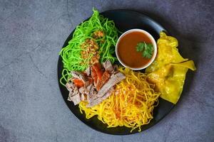 Jade-Nudeln und gelbe Nudeln asiatisches thailändisches Essen, gebratene Ente mit Jade-Nudeln und Schweinefleischknödel auf Teller und Entensauce, grüne Nudeln, chinesisches Essen foto