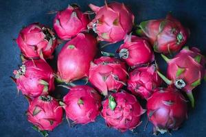 drachenfrucht pitahaya auf dunklem hintergrund, frische drachenfrucht tropisch im asiatischen thailand gesundes fruchtkonzept - draufsicht foto