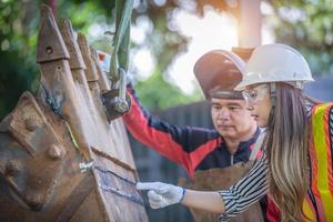 porträt eines schönen asiatischen ingenieurs, der einen schraubenschlüssel hält, der hintergrund ist ein container, ein konzept eines ingenieurs oder eines industriemechanikers. foto