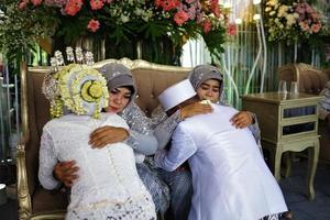 bandung, west java, indonesien, 2021 - muslimischer bräutigam und braut bei der traditionellen indonesischen hochzeitszeremonie von sungkeman foto