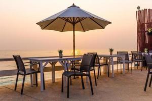 schöne Tischdekoration am Strand bei Sonnenuntergang foto