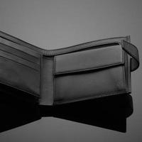 eine Nahaufnahme einer modischen Ledergeldbörse auf einem dunklen Hintergrund foto