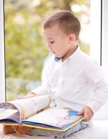 kleiner Junge liest Buch foto