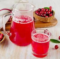 Cranberry-Getränk auf hölzernem Hintergrund foto