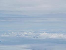 Luftaufnahme der Wolkenlandschaft durch das Flugzeugfenster gesehen foto