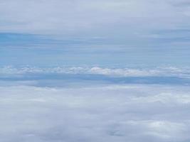 Luftaufnahme der Wolkenlandschaft durch das Flugzeugfenster gesehen foto