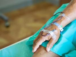 Hand des Patienten des alten Mannes gibt Blut während der Behandlung von Anämie im Krankenhaus foto